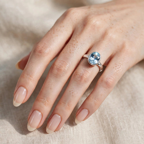 Damenring 925 Silber mit blauem Topas am Finger getragen - filigraner Edelsteinring hellblau an zarter Frauenhand - Tragebild